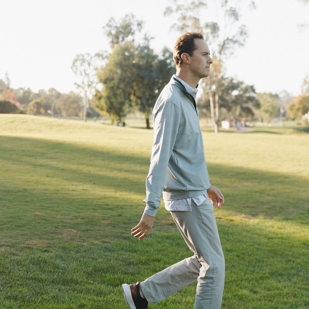The long-sleeve Hunter Quarter zip outerwear piece features a crisp hunter green and white stripe color combination. It's breathability and stretch properties provide optimal mobility from the office to a night out.