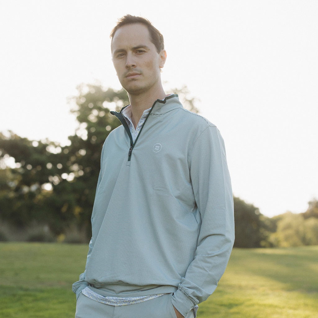 The long-sleeve Hunter Quarter zip outerwear piece features a crisp hunter green and white stripe color combination. It's breathability and stretch properties provide optimal mobility from the office to a night out.
