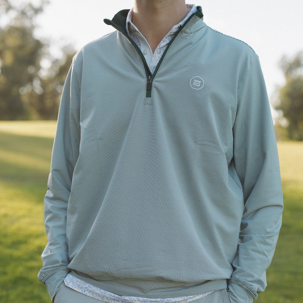 The long-sleeve Hunter Quarter zip outerwear piece features a crisp hunter green and white stripe color combination. It's breathability and stretch properties provide optimal mobility from the office to a night out.