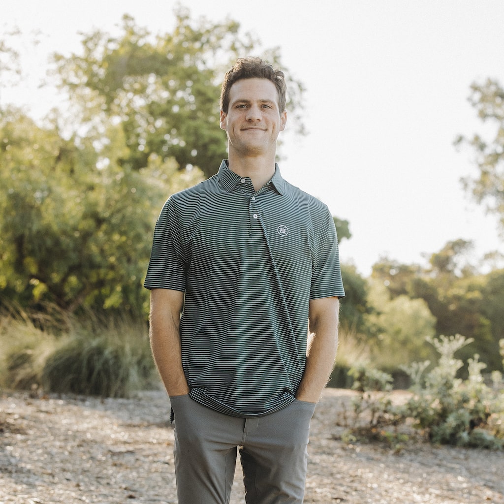This flattering men's performance style golf polo features a hunter green color with white stripes and a breathable, flexible-fit fabric.