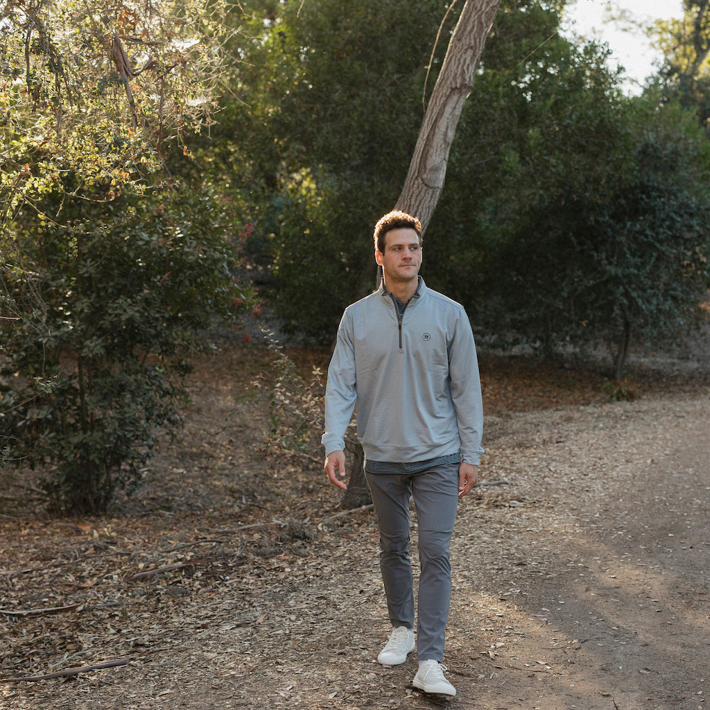 The Grey Quarter Zip outerwear piece features a subtle stripe pattern that flatters all and pairs with your favorite golf polo. It's breathability and stretch properties provide optimal mobility from the office to a night out.