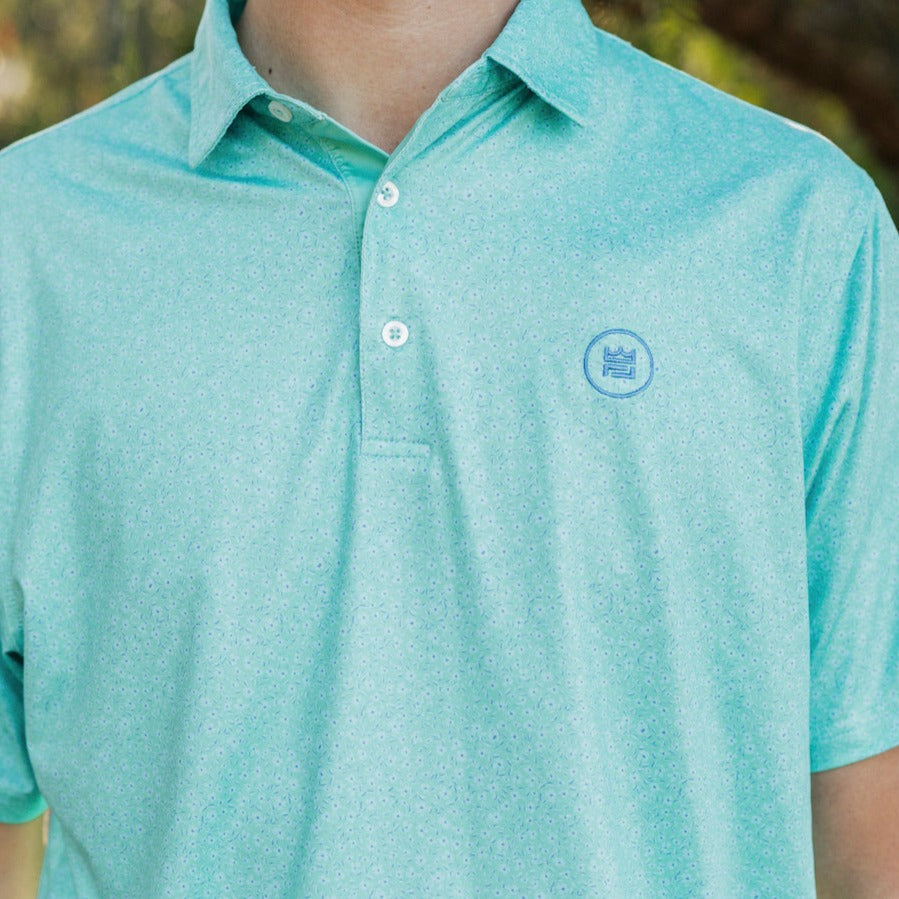 The Turf Polo is a floral performance golf polo with an elevated material and aesthetic to up your game. This delicate green floral print is a beauty.
