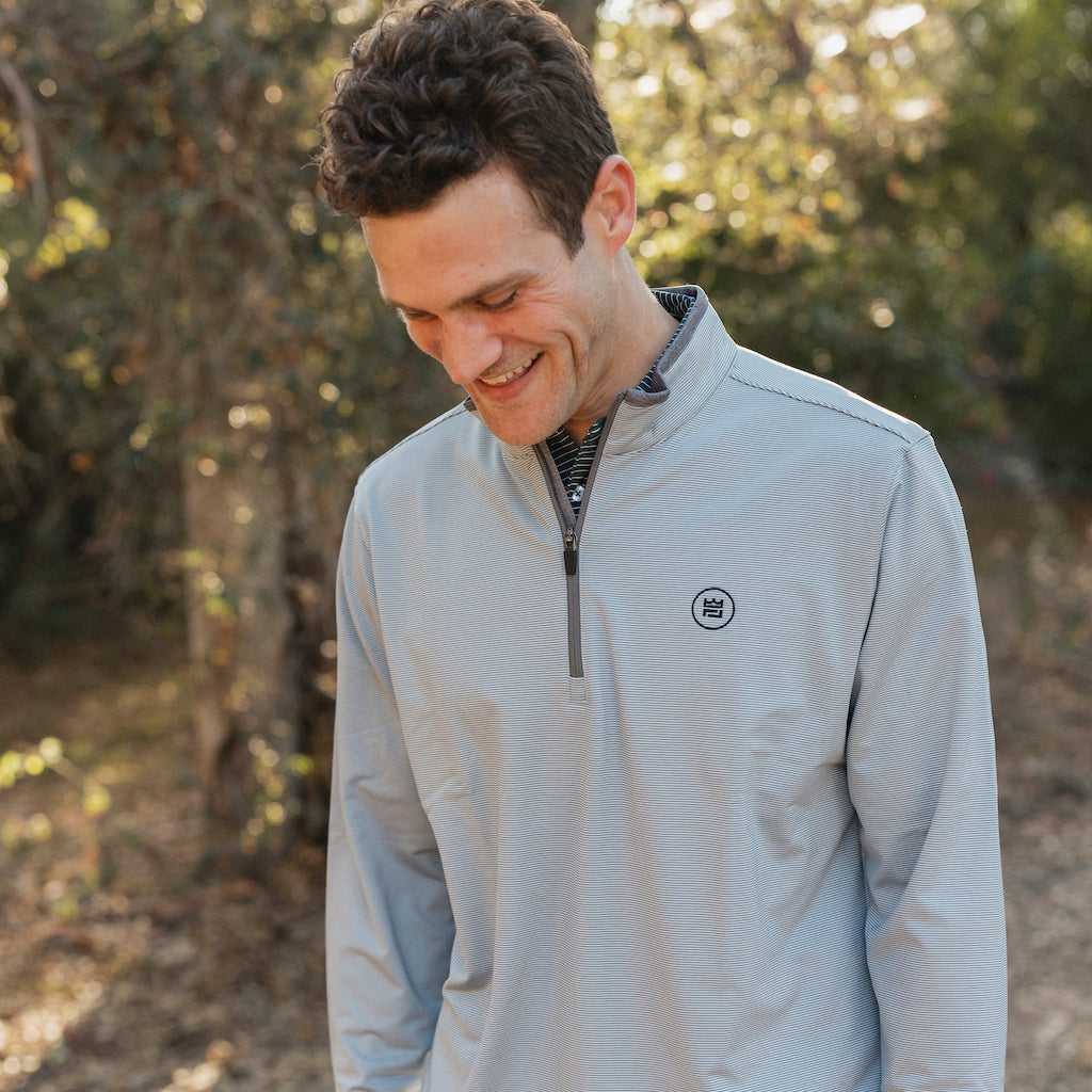The Grey Quarter Zip outerwear piece features a subtle stripe pattern that flatters all and pairs with your favorite golf polo. It's breathability and stretch properties provide optimal mobility from the office to a night out.