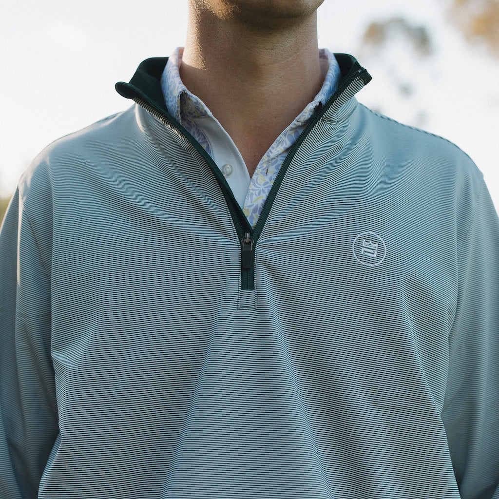 The long-sleeve Hunter Quarter zip outerwear piece features a crisp hunter green and white stripe color combination. It's breathability and stretch properties provide optimal mobility from the office to a night out.