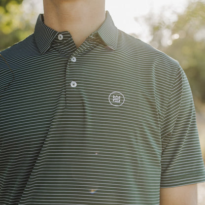 This flattering men's performance style golf polo features a hunter green color with white stripes and a breathable, flexible-fit fabric.