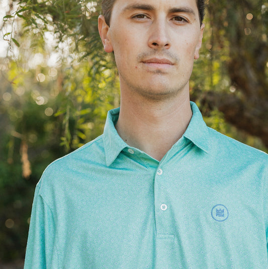 The Turf Polo is a floral performance golf polo with an elevated material and aesthetic to up your game. This delicate green floral print is a beauty.