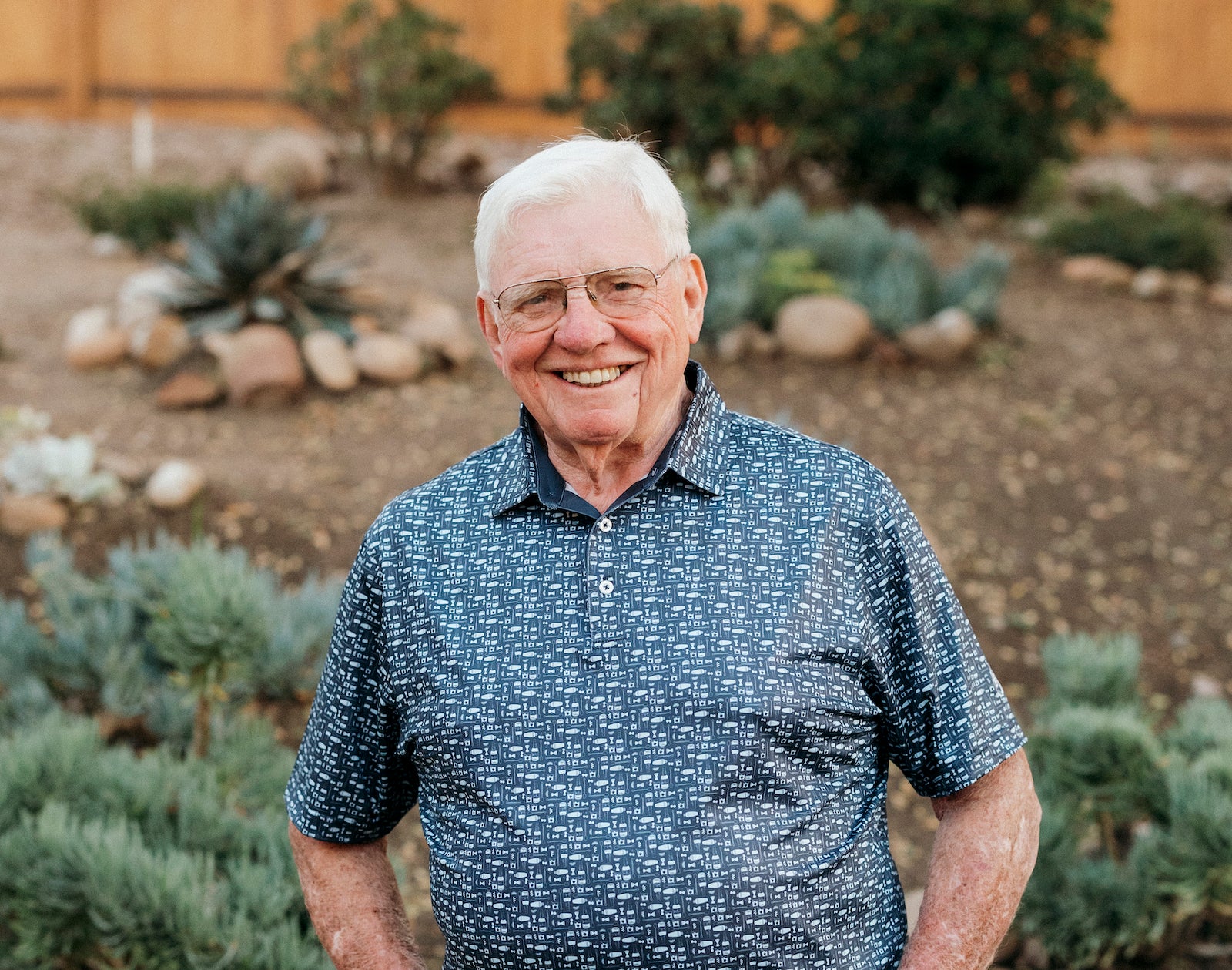 Grandpa Botsford wearing The Old Fashioned Polo, a brand new design featuring an Old Fashioned cocktail print and our classic performance golf polo fit. The Old Fashioned Polo is shown here in dark blue.